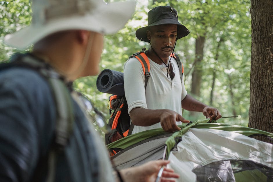 A family setting up a camping tent in the wilderness