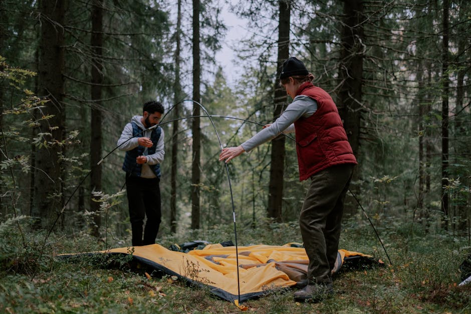 A family setting up a camping tent in the outdoors