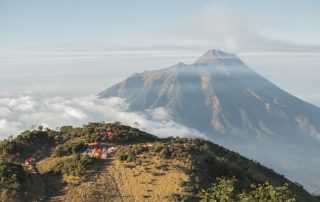 Various types of camping tents set up in a beautiful natural landscape
