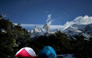 Various types of camping tents set up in a scenic outdoor location